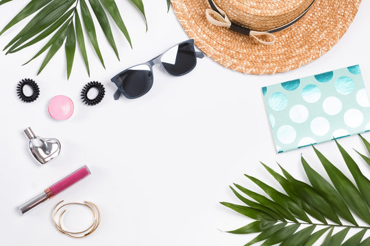 Vacation flat lay with straw hat, palm leaves and other