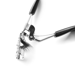 Curler and false eyelashes on white background