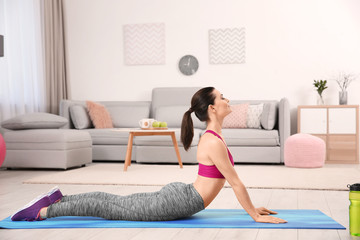 Young sporty woman doing exercise at home