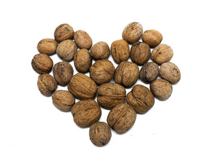 Nuts lie in the shape of heart on a white background
