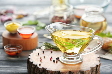 Gravy boat with tasty salad dressing on decorative stump