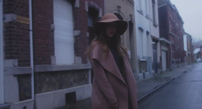 TRACKING SHOT Beautiful Caucasian female in stylish outfit walking in the streets of old European city, urban background. 4K UHD 60 FPS SLO MO