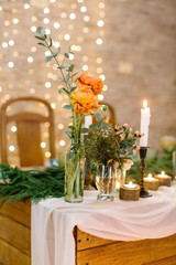 decor, romance, dating concept. close up of two posies in different in forms transparent vases, that are placed on the edge of the dining table on the background of blured lights