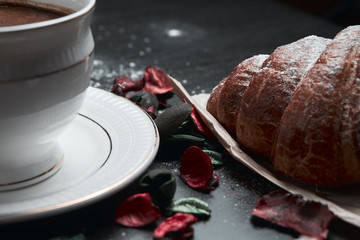 coffee and croissants on black background