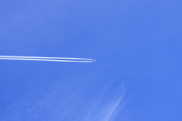white airplane trace against the blue sky