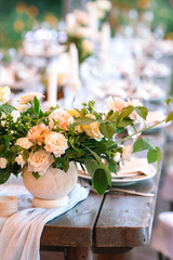 floral design, wedding, summer concept. close up of not large tidy bouquet of chic fresh marvelous flowers named roses avalanches in light peachy color placed on the wooden vintage table