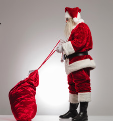 santa claus tyeing his presents bag