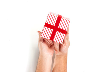 Male hands holding gift, red white gift box with ribbon, isolated on white background, top view. Isolate. New Year, Christmas, birthday.
