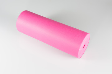 Roll of pink colored wrapping foil on white background