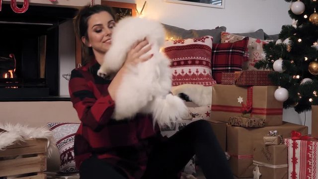Woman cuddling her cute small dog at christmas 