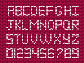 White knitted alphabet and numerals on burgundy knitted fabric background.
