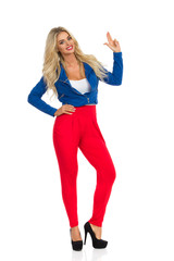 Fototapeta premium Smiling Sexy Blond Woman Is Standing And Showing Pistol Hand Sign