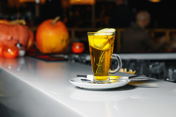 Green tea with apple slices in a glass cup on a white bar counter