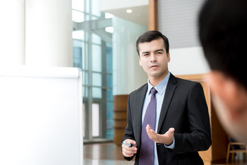 Handsome bussinessman presenting business activity plan to his colleagues