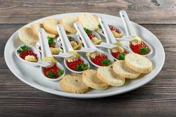 Red caciar served with crispy rusks on a plate decorated with greens and mayonase menu eating food delicious portion luxury restaurant tasty hunger appetizers concept.