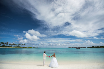 Fototapeta na wymiar Young couple holding hands on a seaside