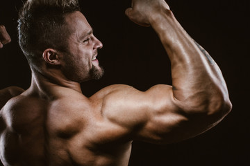 Fototapeta na wymiar Handsome bodybuilder posing on black background