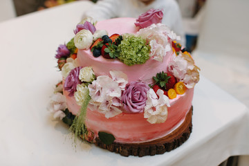 Pink wedding cake decorated with fresh flowers