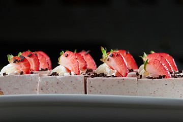 Close up shot of strawberries on top of a delicious cheesecake sweet sugar dairy food eating desser hungry restaurant cafe baking coffee shop pastry concept.