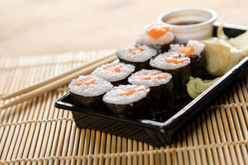 Lachs Maki Sushi vom Lieferdienst mit Ingwer, Wasabi, Sojasoße und Holz Stäbchen