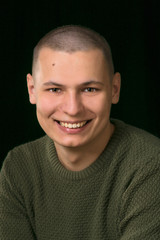 Obraz premium a stylish young man in a green military style sweater. Studio.