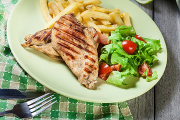 Grilled chicken breasts served with fries