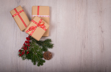 Christmas gift and ornaments with pine tree and cone over a wood background