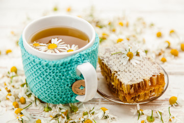 Honeycomb and chamomile tea on white