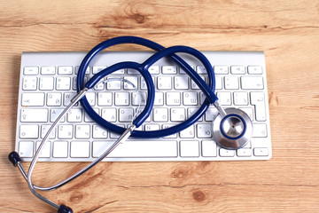 Tablet computer with a stethoscope lie on a table