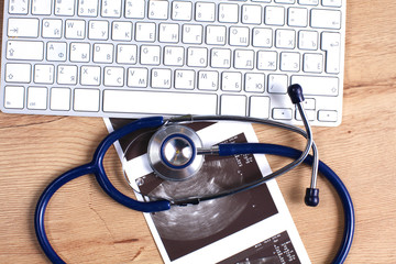 Tablet computer with a stethoscope lie on a table