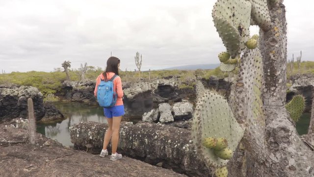 Galapagos tourist visiting Los Tuneles aka The Tunnels on Isabela Island, Galapagos Islands. Famous visitor site for sightseeing, snorkeling and diving boat day tour. Happy woman looking at nature.