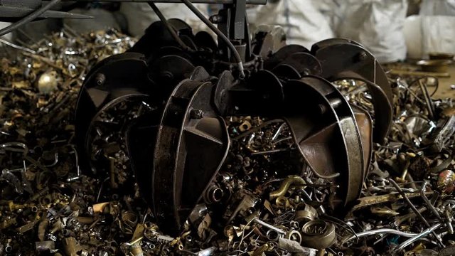 View of metal grabber taking heap of rusty pieces for recycling