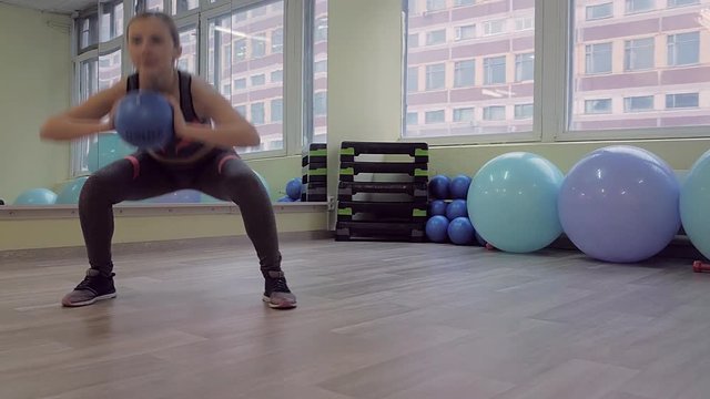 Young woman doing fitness indoors, doing stretching. girl shakes the press. healthy lifestyle and sports. the camera moves.