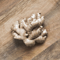 Ginger root on brown wooden background.