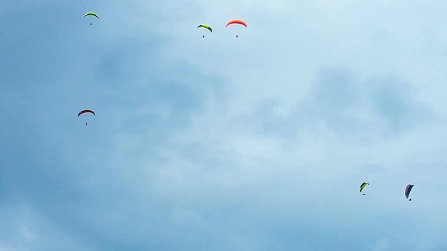 Paragliding as extreme and fun sport. Paragliders flying high in the sky