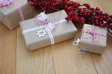 Pacchi regalo natalizi con fiocchi e decorazioni su tavolo di legno. Sfondo di Natale