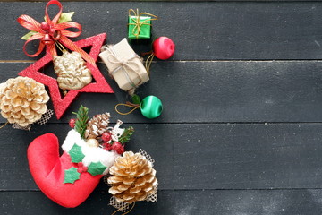 Christmas background with red sock,gift box,pine,candy on wooden black background  ,top view for copy space