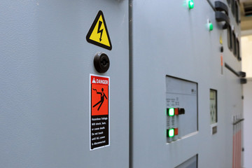 Hazardous voltage sign in main distribution board of electric plant. Warning sign on electric...