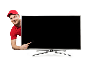 smiling young man in red uniform pointing on blank tv screen