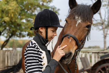 Obraz premium Love my horse! - A young girl lays her horse on the head