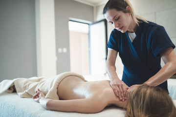 Masseur treating patient with therapeutic massage