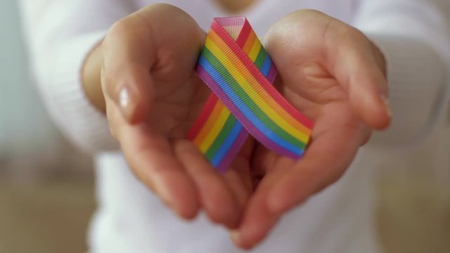 woman holding gay or lgbt pride awareness ribbon