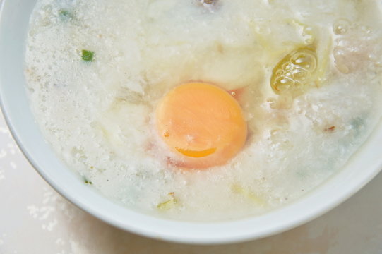 rice porridge with pork topping egg yolk on bowl