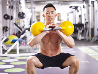 asian bodybuilder exercising in gym