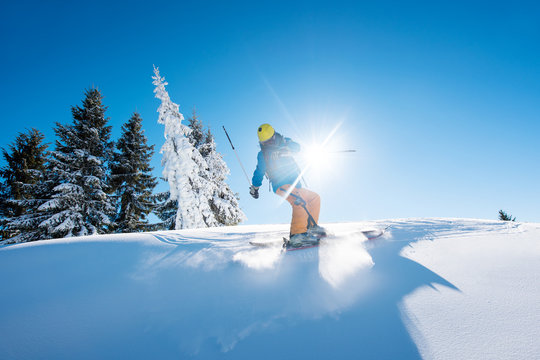 Freeride skier riding down the slope in the mountains copyspace powder snow movement motion active lifestyle seasonal concept