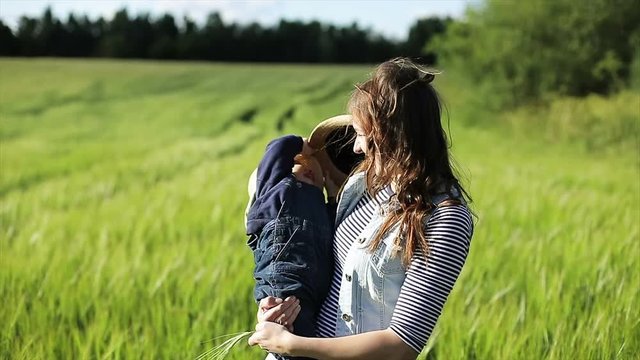 Mother and little son in the wheat field at summer.