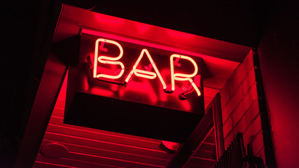 Bar neon light sign lit up at night