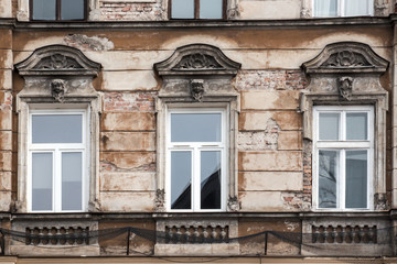 Fototapeta na wymiar Three Windows on the facade of the old shabby house