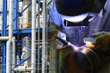 Abstract scene of welding operator and industrial pipeline.