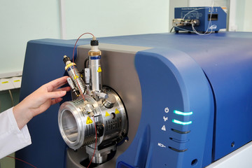 Adjust the mass spectrometer. The man analyzes the device for determining the masses of atoms....